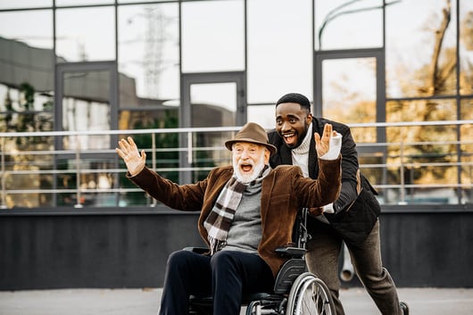 Hommes souriant promenant un homme en fauteuil roulant enthousiaste