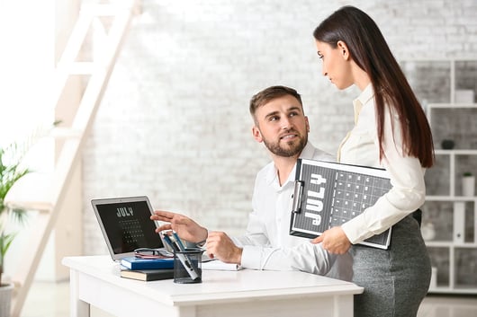 Employé utilisant un calendrier sur son écran au travail