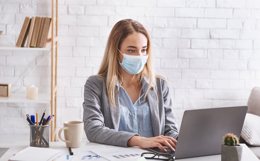 Jeune femme blonde portant un masque au travail